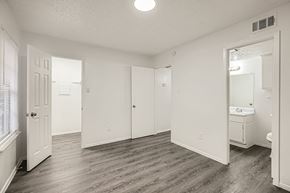 Dallas apartment for rent - A spacious bathroom with a sink, mirror, and wooden flooring.