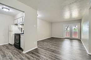 Dallas apartment for rent - A kitchen area with a refrigerator, oven, and a window with blinds.