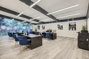 Dallas apartment for rent - A modern office space with blue chairs and wooden floors.