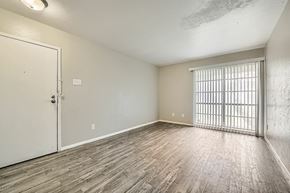 Dallas apartment for rent - A room with a white door and a window with bars on it.