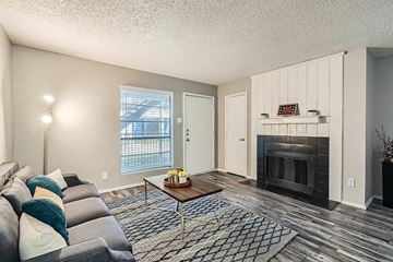 Fort Worth apartment for rent - A living room with a grey couch and a fireplace.
