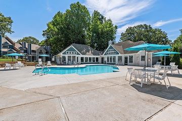 Greensboro apartment for rent - A large outdoor swimming pool with a patio and lounge chairs.