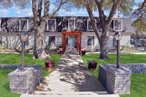 Fort Worth apartment for rent - A pathway leads to a building with a red gate.
