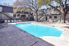 Fort Worth apartment for rent - A small pool surrounded by a concrete floor and a building in the background.