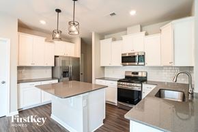 Troutman house for rent - A kitchen with a stove top oven and a microwave above the stove.