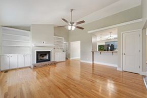 Sneads Ferry house for rent - A living room with a fireplace and a ceiling fan.