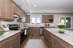 Brandon apartment for rent - A kitchen with brown cabinets and a patterned rug on the floor.