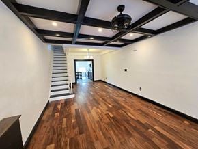 Baltimore house for rent - A room with wooden floors and a staircase.