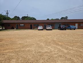 Prentiss apartment for rent - A parking lot with a building and cars parked in front.