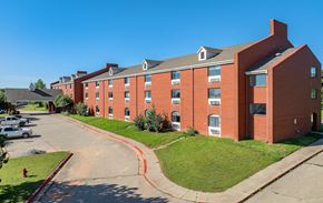Edmond apartment for rent - A red brick building with a green lawn in front.