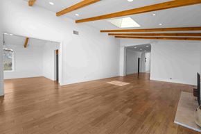 Los Angeles house for rent - A spacious room with wooden floors and white walls.