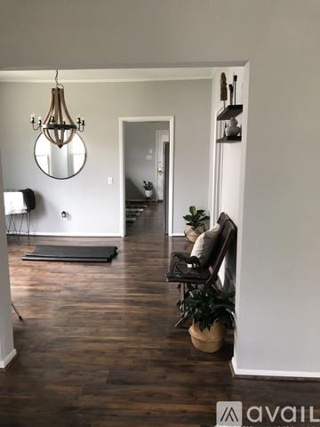 St. Joseph apartment for rent - A living room with a black chair and a round mirror on the wall.