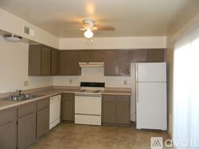 Phoenix house for rent - A kitchen with white appliances and brown cabinets.