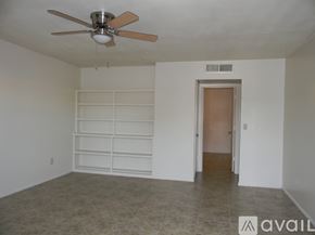 Phoenix house for rent - A room with a ceiling fan and a door leading to another room.