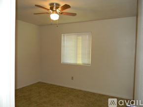 Phoenix house for rent - A room with a ceiling fan and a window with blinds.