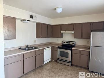 Phoenix house for rent - A kitchen with brown cabinets and a stove top oven.