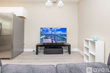 Pensacola house for rent - A living room with a television and a grey couch.