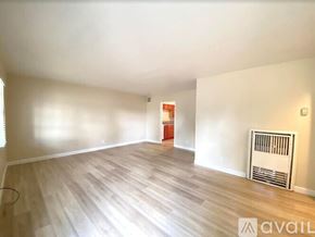 Merced apartment for rent - A room with wooden flooring and a radiator on the wall.