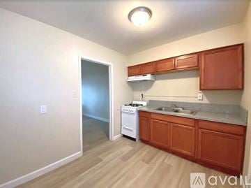 Merced apartment for rent - A kitchen with wooden cabinets and a white dishwasher.