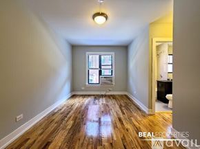 Chicago apartment for rent - A room with wooden floors and a window with blinds.