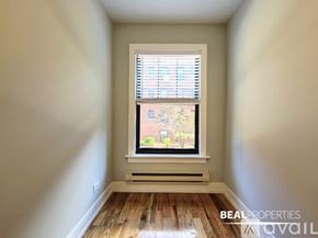 Chicago apartment for rent - A room with a window showing a view of a tree and a building outside.