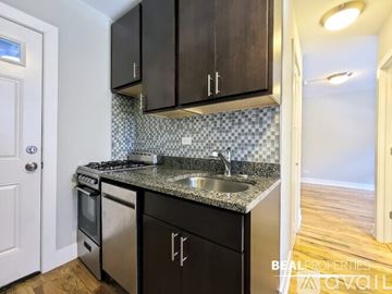 Chicago apartment for rent - A kitchen with black cabinets and a checkered backsplash.