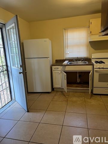 Atlanta house for rent - A kitchen with a white fridge, white stove, and white oven.
