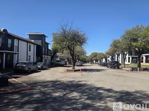 Fort Worth apartment for rent - A sunny day in a parking lot with cars and buildings.