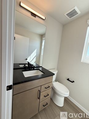 Colorado Springs house for rent - A kitchen with black cabinets and a countertop with a white towel on it.