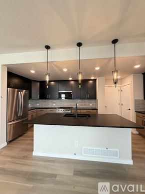 Colorado Springs house for rent - A spacious room with wooden flooring and a large window.