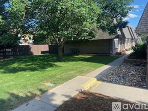 Longmont apartment for rent - A tree in a yard with a house in the background.