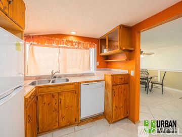 Spokane house for rent - A kitchen with wooden cabinets and a white dishwasher.