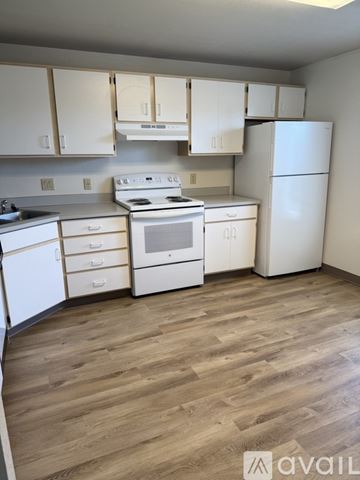 Yakima house for rent - A kitchen with white appliances and wooden floors.