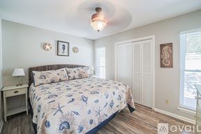 Hilton Head Island house for rent - A bedroom with a bed, nightstand, and two pictures on the wall.