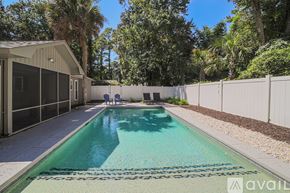 Hilton Head Island house for rent - A pool surrounded by a white fence and trees.