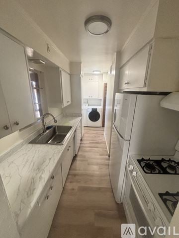 Tucson house for rent - A kitchen with white cabinets and a marble countertop.