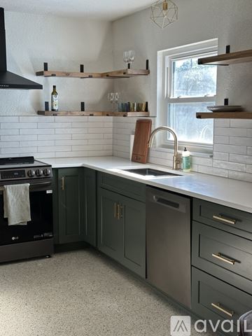 Gulfport house for rent - A kitchen with a black oven and green cabinets.