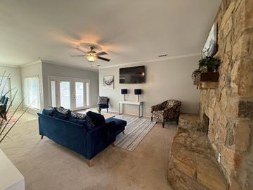 Flower Mound house for rent - A living room with a blue couch and a stone fireplace.