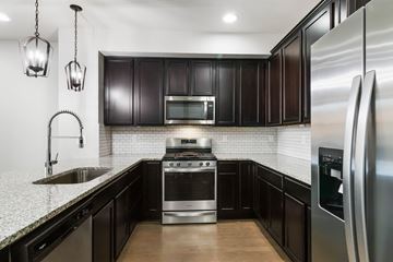 Parker house for rent - A modern kitchen with dark wood cabinets and stainless steel appliances.