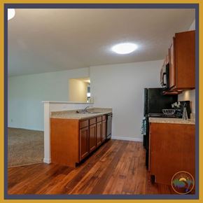 Dayton apartment for rent - A kitchen with wooden cabinets and a black refrigerator.