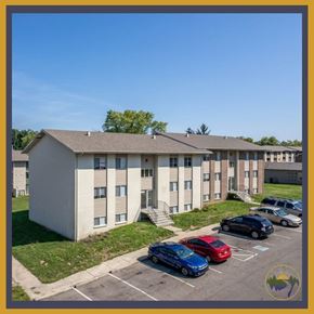 Dayton apartment for rent - A parking lot with several cars in front of a building.