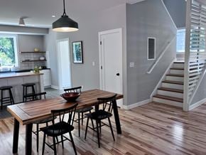 Charlottesville house for rent - A kitchen with a table and chairs in the foreground and a staircase in the background.