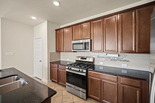 Richmond house for rent - A kitchen with brown cabinets and a stove top oven.