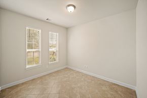 Richmond house for rent - A room with beige tiled flooring and two windows.