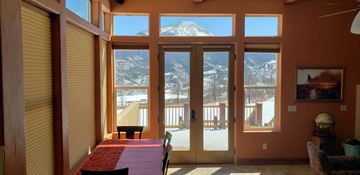 La Veta house for rent - A dining room with a table and chairs and a view of the mountains.