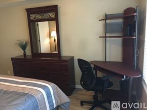 Murray condo for rent - A bedroom with a bed, desk, chair, and a mirror.