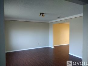 Grand Prairie house for rent - A room with a wooden floor and a yellow wall.