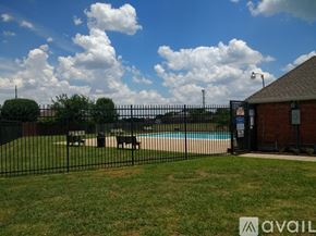 Grand Prairie house for rent - A pool surrounded by a black fence with a small building to the right.