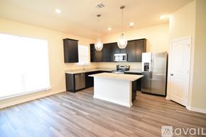 Temple house for rent - A kitchen with a white island and stainless steel appliances.