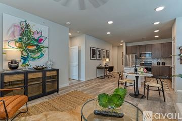 Melissa apartment for rent - A modern living room with a large painting on the wall and a dining area in the background.